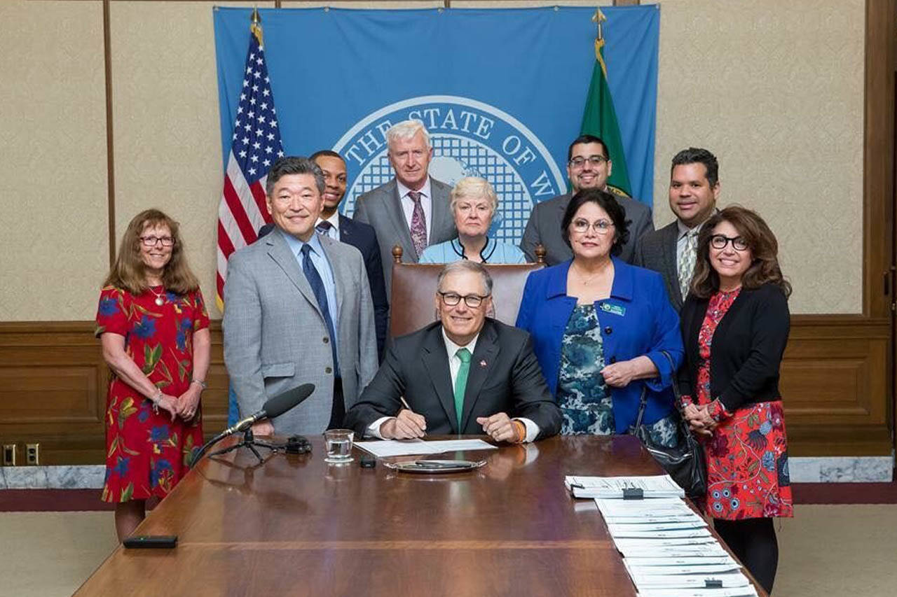 Anita Ahumada al centro y el Gobernador Jay Inslee junto a otras personas en el evento.
