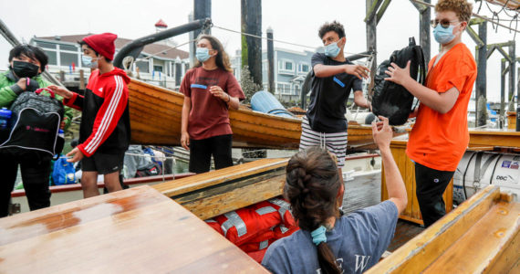 Members of Casino Connect line up to stow luggage Tuesday morning aboard the Adventuress in Everett on August 9, 2022.  The teens will go on a four-day sailing trip where they learn about maritime skills and environmental science. (Kevin Clark / The Herald)
