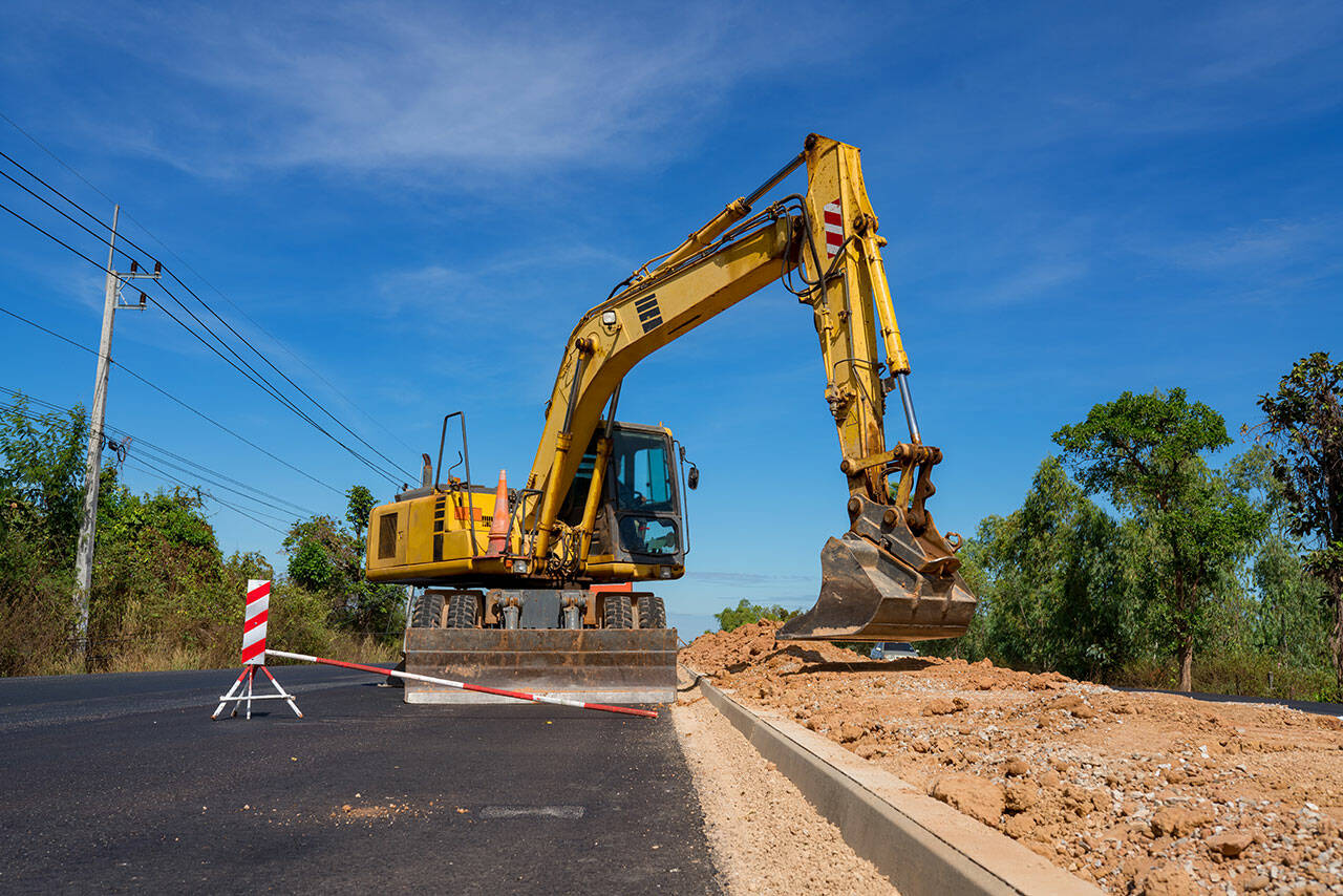 Construction site  backhoe dig the ground in road construction.